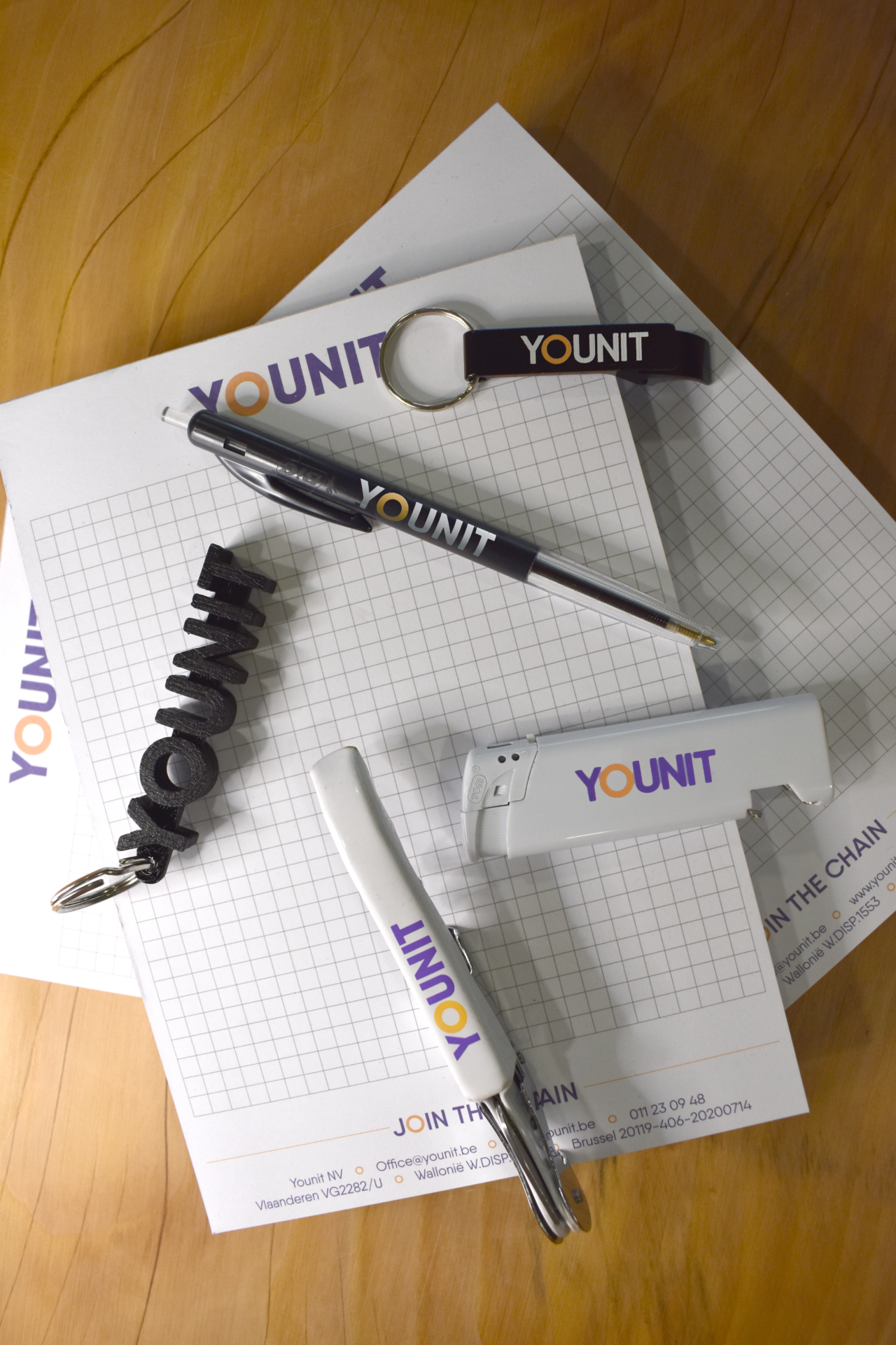 Enkele gadgets van Younit waaronder een aansteker, een pen en een sleutelhanger