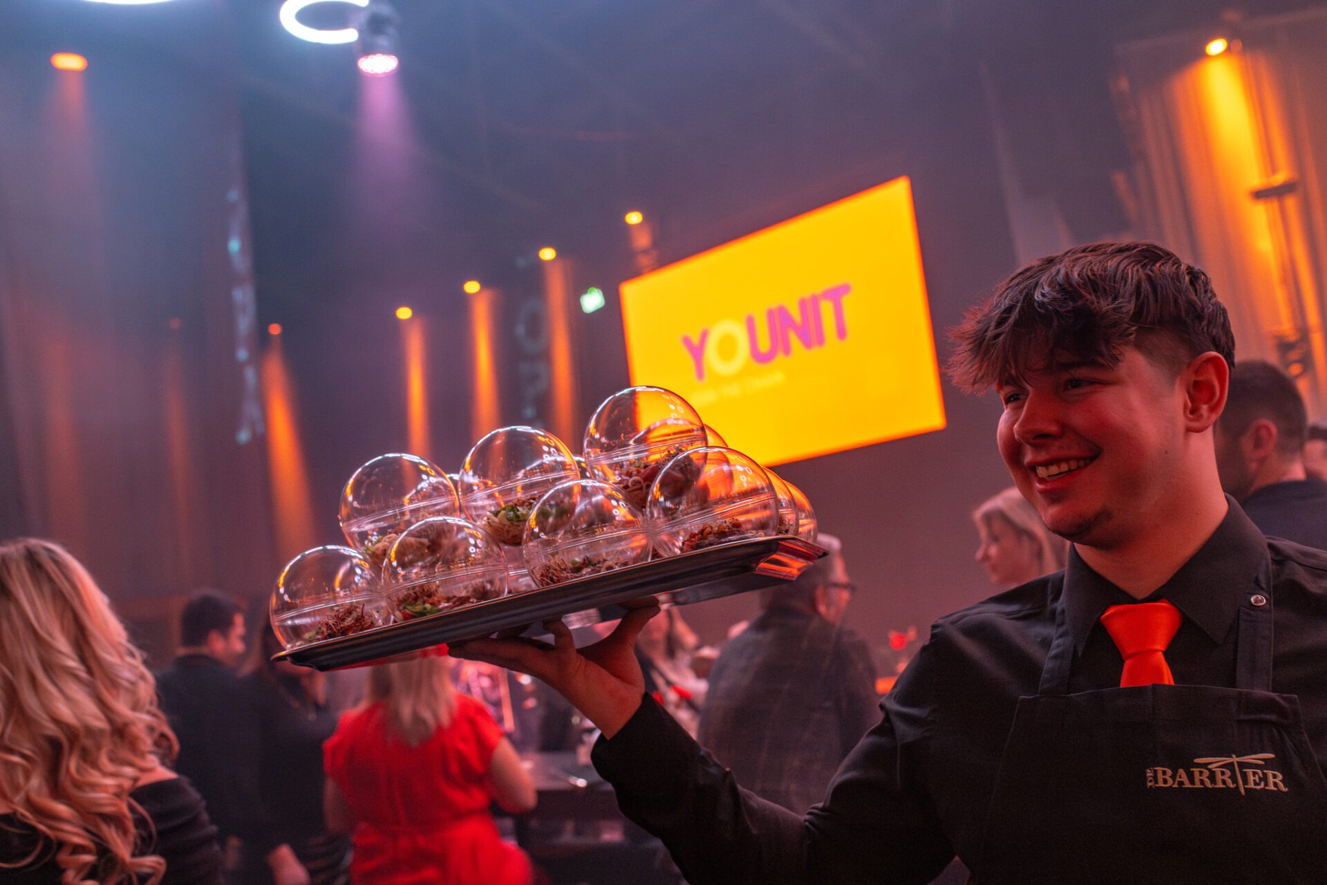 Kelners van Younit op een evenement Nieuwjaarsinvitito 2024 van Jong Voka Limburg die rondgaan met hapjes